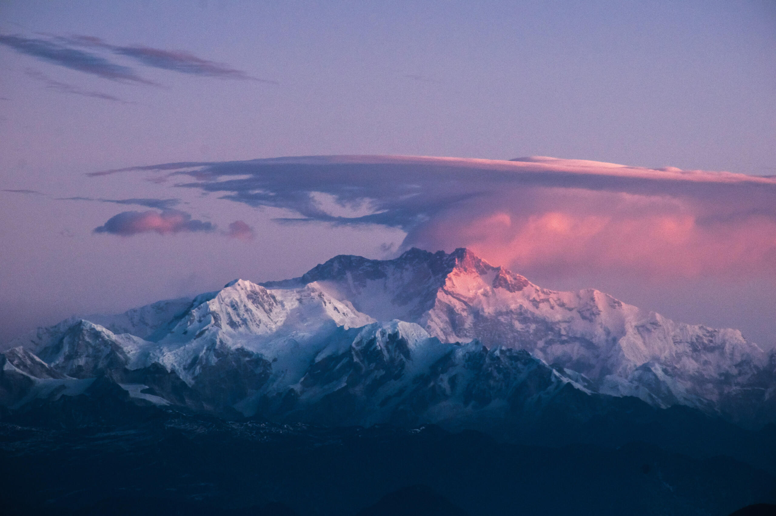 The Kanchenjunga range bathed in purply-pink light — a glimpse of the Himalayas that shaped Evelyn’s story. Purply-pink sunset over the Kanchenjunga mountain range in the Himalayas, inspiration for Penelope Clare’s historical fiction.
