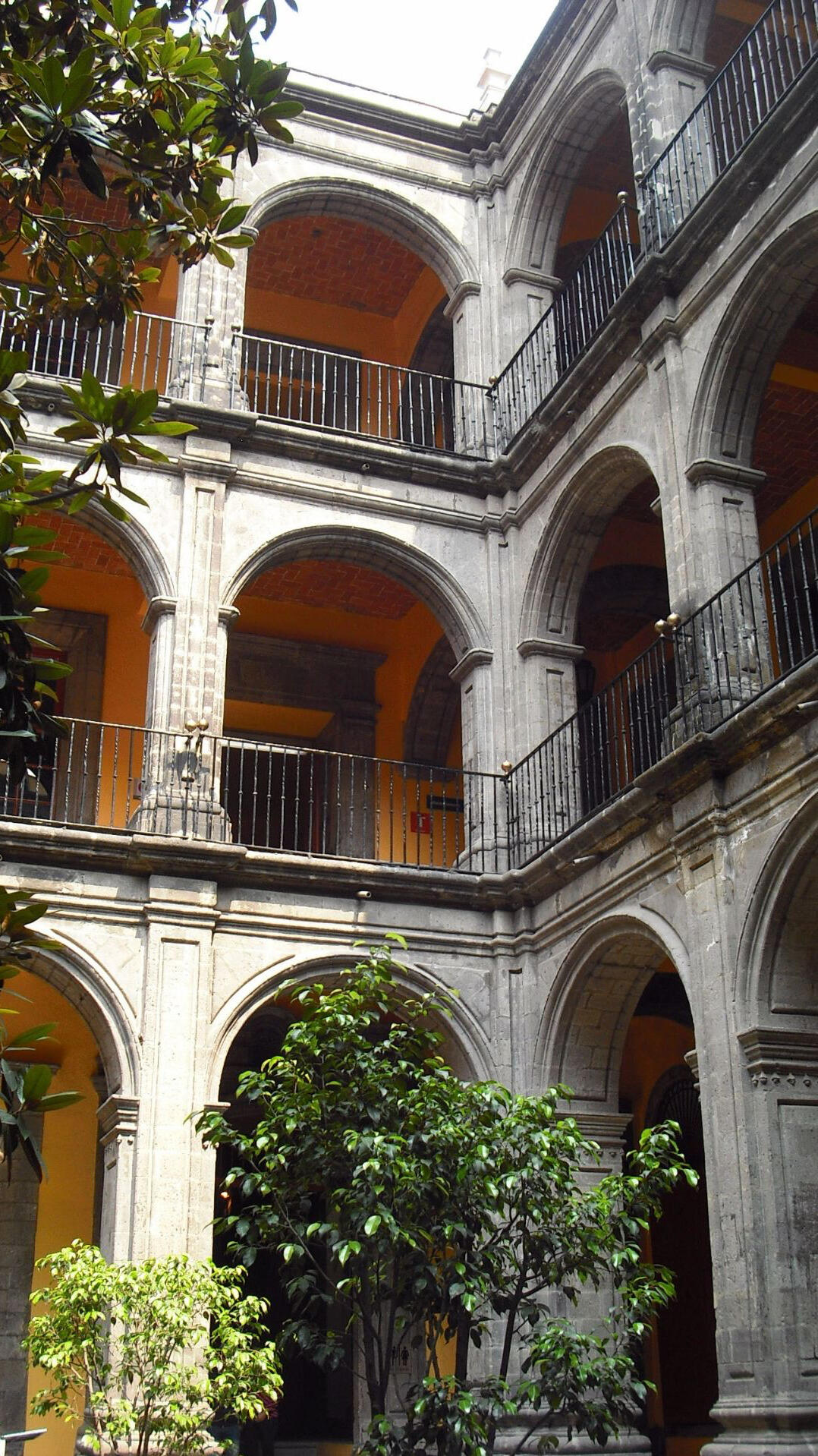 White Arched Haveli Courtyard, India Historic Indian haveli with white arches, yellow inner courtyard walls, and iron balustrades.
